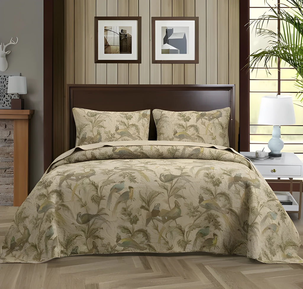 Blue American floral and bird pattern cotton bedspread quilted set of three pieces on a bed.