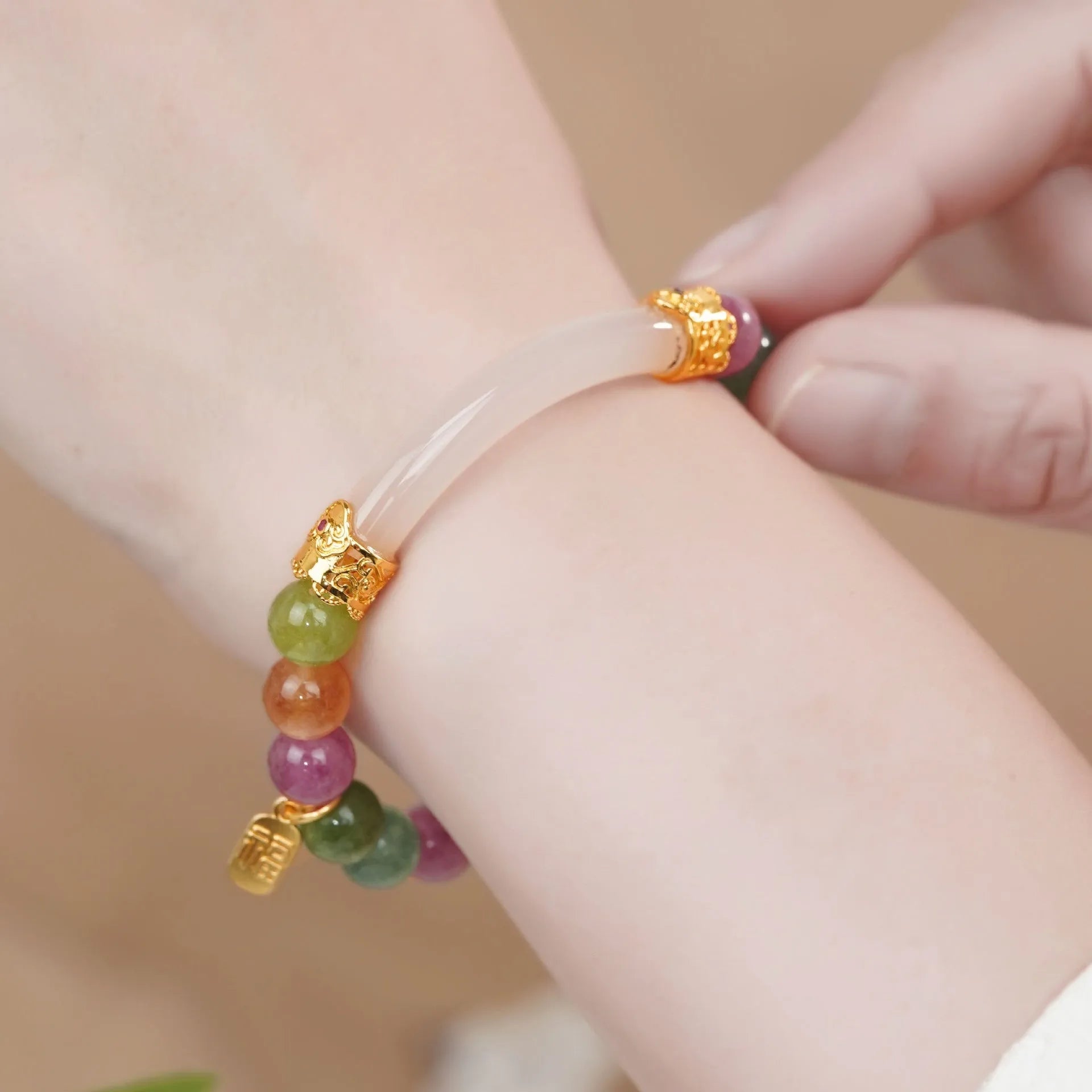 Natural rainbow coloured tourmaline gemstones on a women's jade pith half bracelet with electroplated finish.