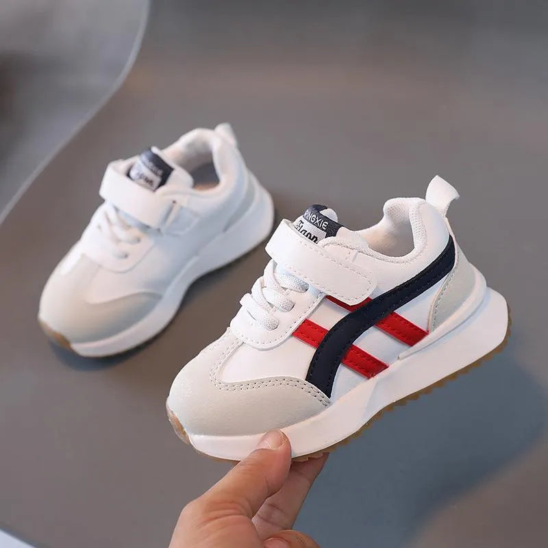Children's solid-colour sneakers with Velcro strap in white, beige, or khaki on a rubber sole.