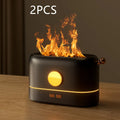 Black USB humidifier with flickering flame effect on a wooden desk next to a plant.
