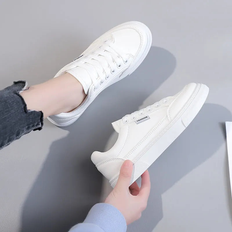 Korean-style white low-top women's sneakers made from artificial PU leather with a plastic sole.