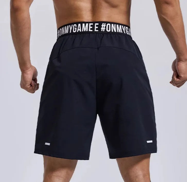Men's loose grey cropped sports shorts with letter detailing and an elastic fly opening.