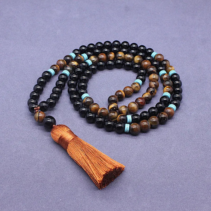 Close-up of black agate and tigereye geometric bead bracelet and necklace set on neutral background