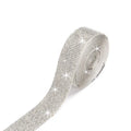 Self-adhesive water drill strip for clothing decoration in white and AB colour on a fabric background.