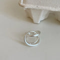 Geometric open ring for women with a three-dimensional interlaced design in matte metal.