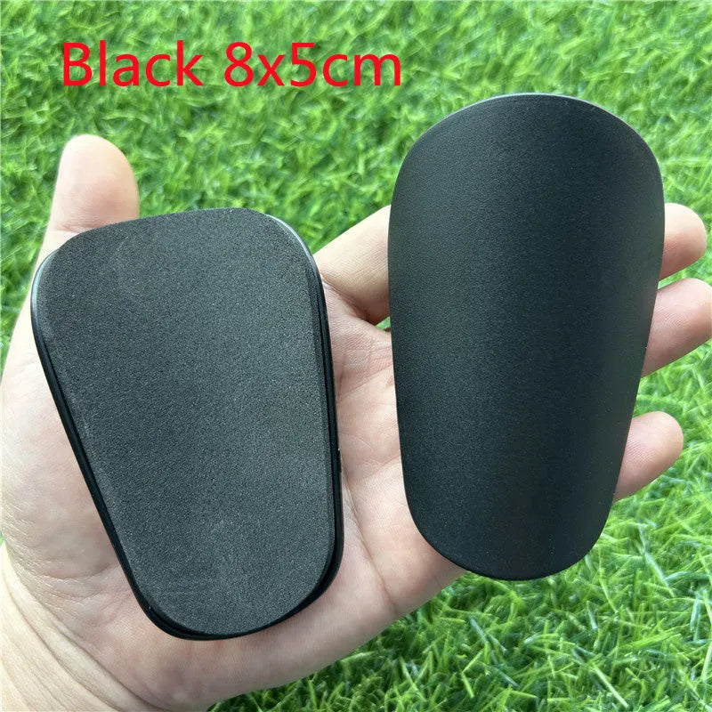 Extra small plastic football shin guards measuring 8cm by 5cm with elastic straps