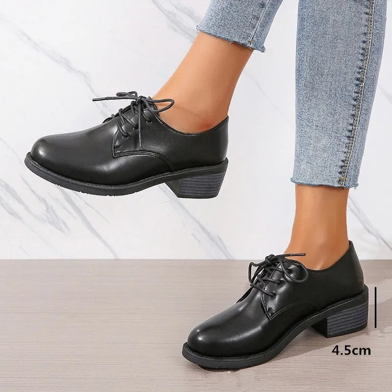 Black women's lace-up work shoes with a thick chunky heel and soft rubber sole.