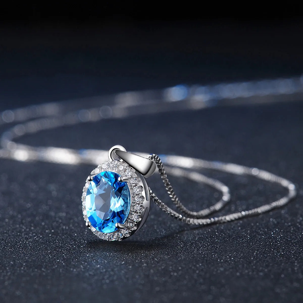 Women's 925 sterling silver and blue topaz four-piece jewellery set with geometric design, showing earrings, ring, necklace, and pendant.