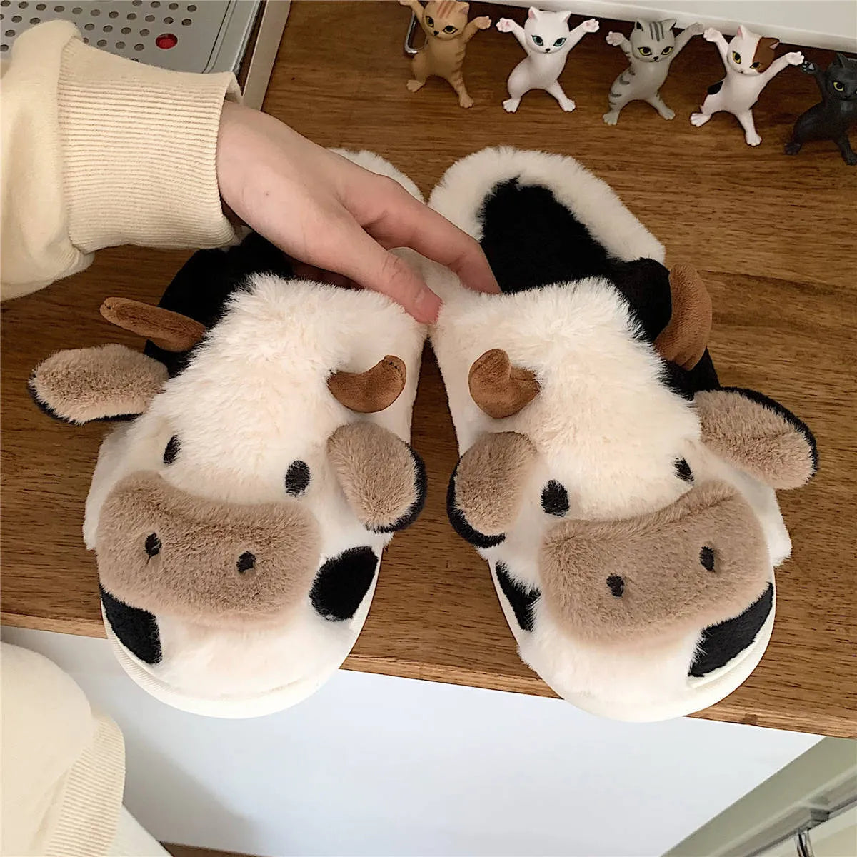 White plush cow-themed house slippers for women with a non-slip textured sole.