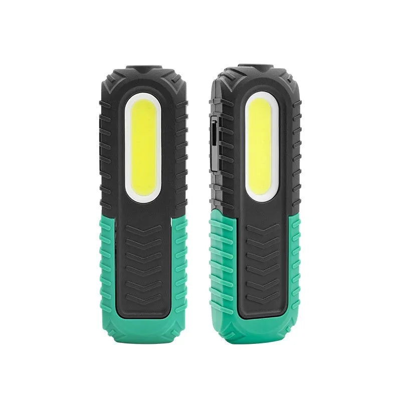 Black and green USB rechargeable automotive inspection work light on a workshop bench.