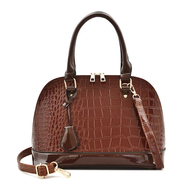 Large shiny black PU crossbody shoulder bag with shell shape design on a model.