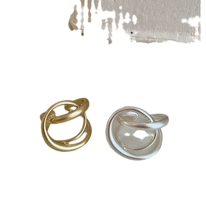 Geometric open ring for women with a three-dimensional interlaced design in matte metal.