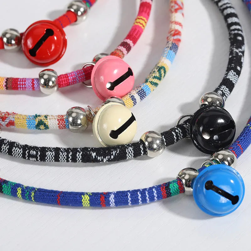 Coloured ethnic style adjustable pet collar with a bell for cats and dogs in black, blue, pink, red, and white.