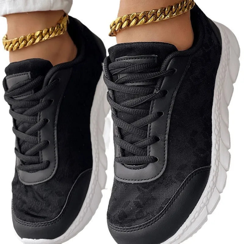 Women's white canvas running shoes with soft sole and round toe on a flat heel.