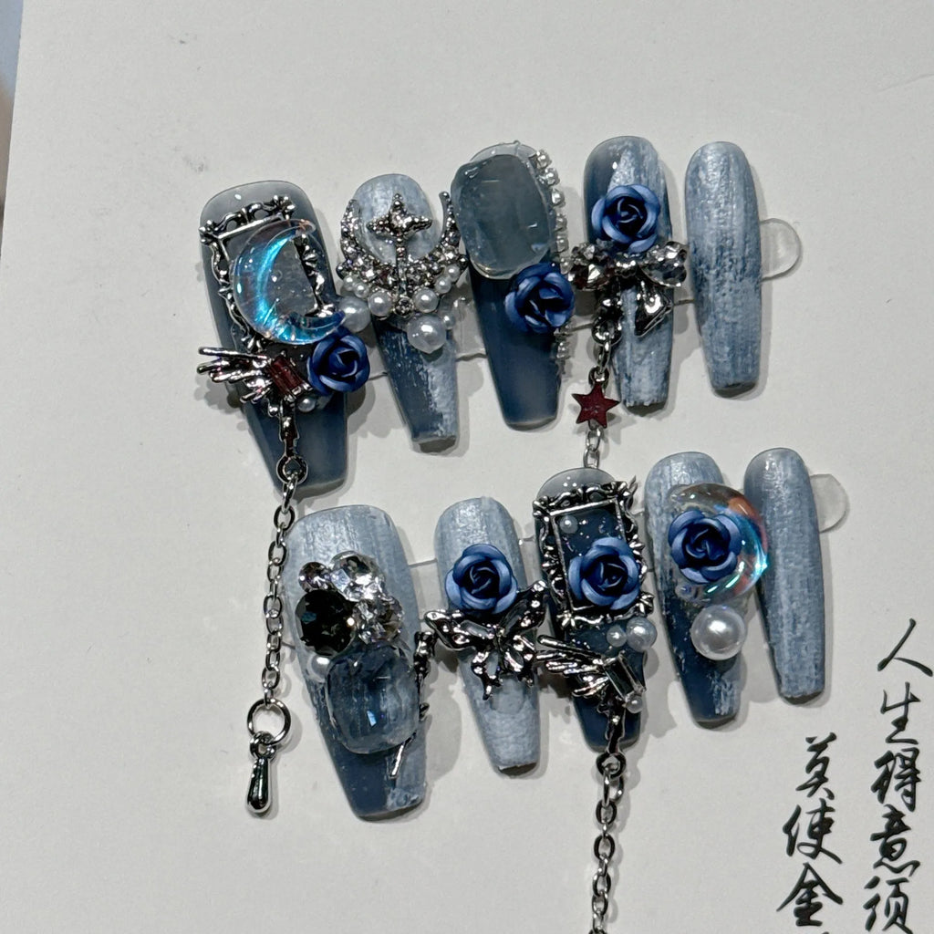 False nails with heavy industry blue colour and ornate rose and tulip flower patterns.