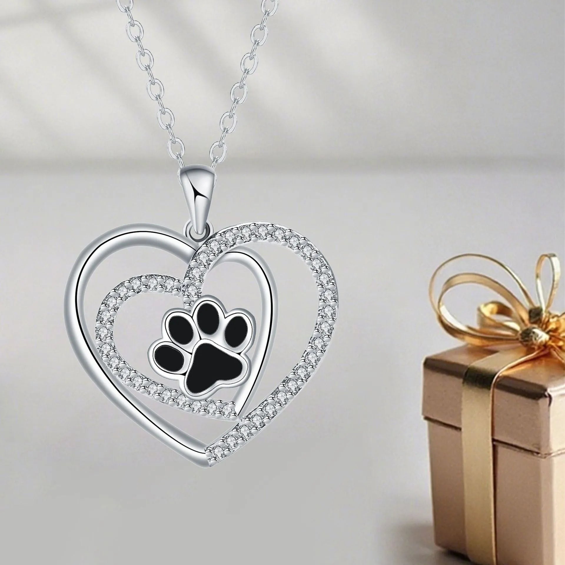 Women's necklace with a copper dog paw print heart pendant on a cross chain.