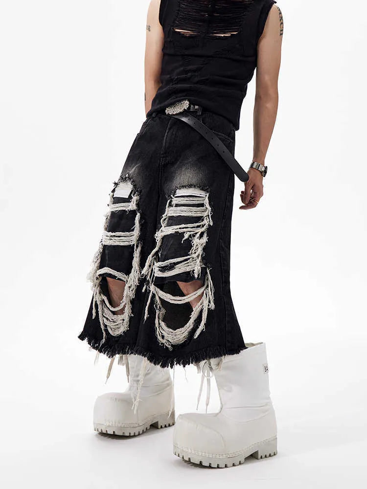 Black wide leg cropped jeans with mid-high waist and ripped patch detail on the legs.