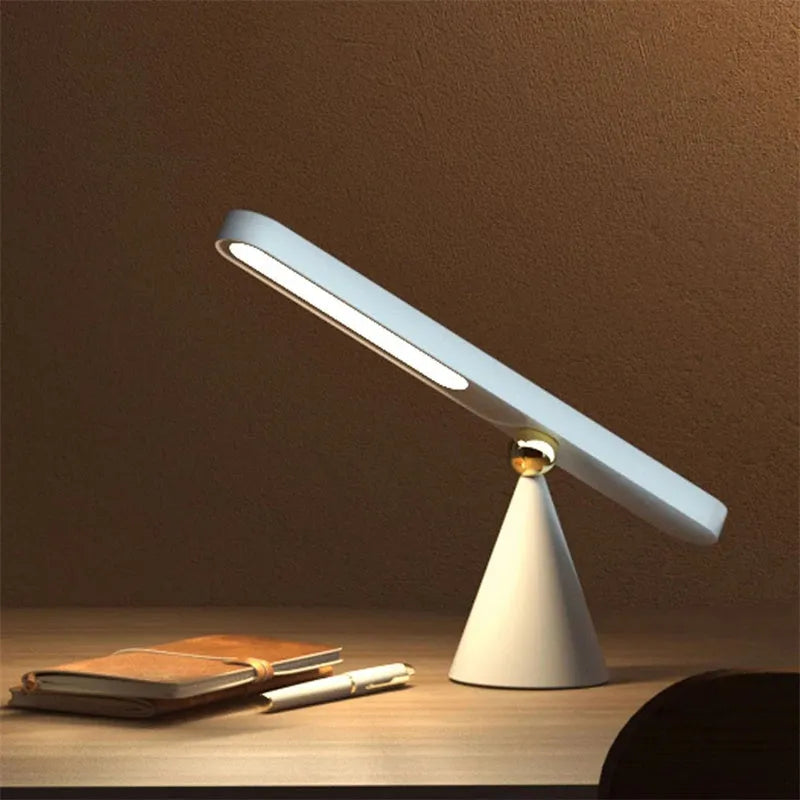 Geometric white desk lamp with magnetic base and USB cable on wooden table