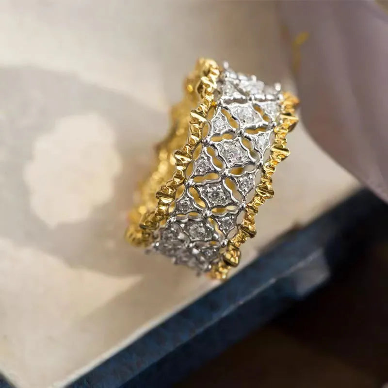 Geometric two-tone gold zircon fashion ring on a white background, showing its angular shape and round details.