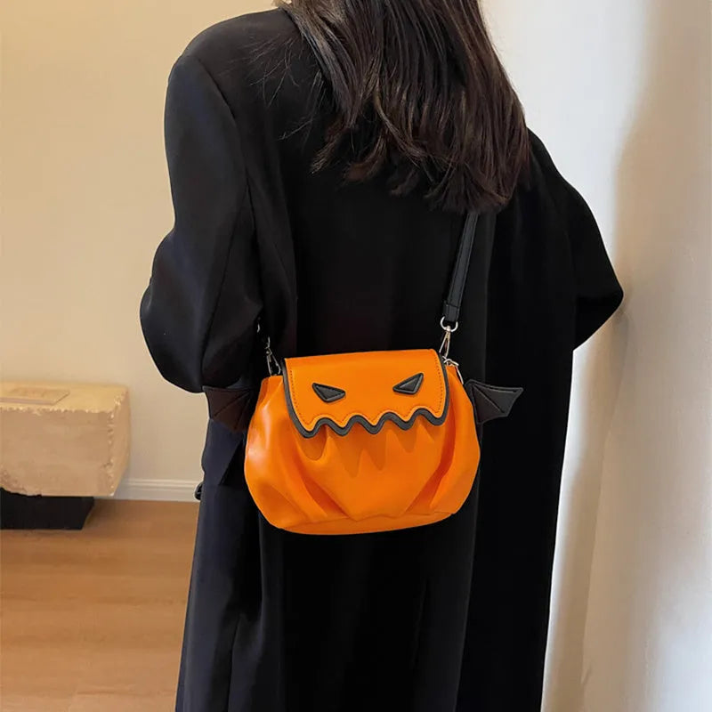 Orange PU crossbody bag with pumpkin cartoon shape and small wings, placed on a neutral background
