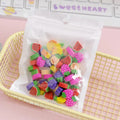 Assortment of colourful TPR cartoon mini erasers showing fruit, animal, and cake designs from a 50-piece pack.