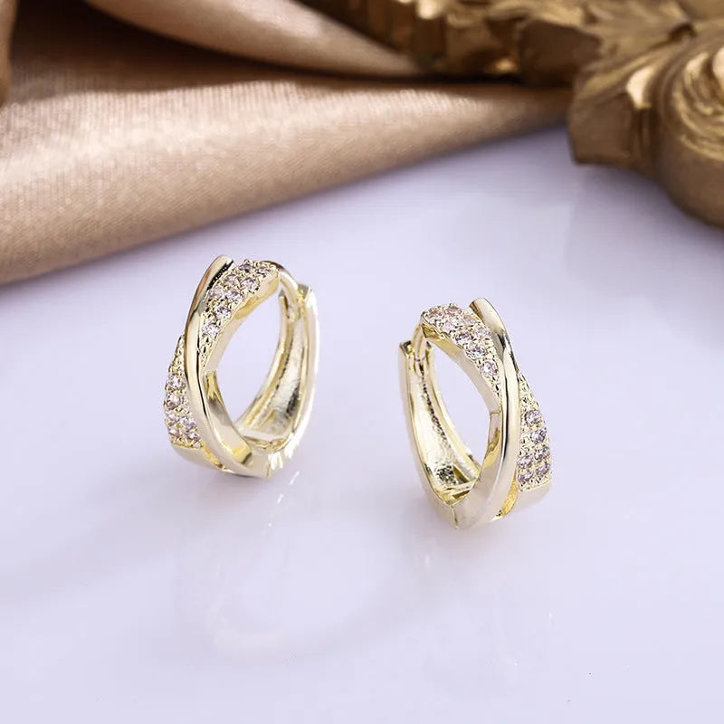 A pair of 14K yellow geometric shaped stud earrings on a plain background.