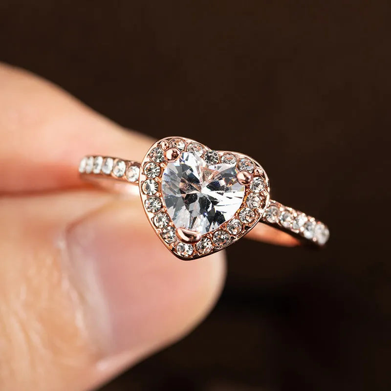 Women's fashion crystal heart-shaped ring in rose gold or silvery on a white background.