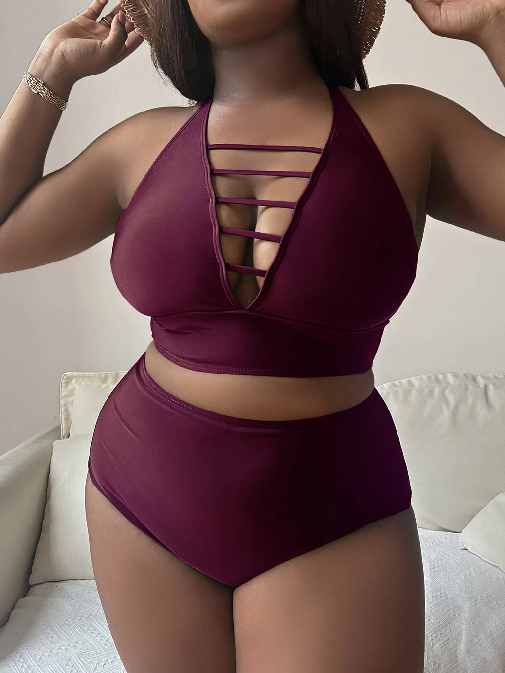 Plus size woman modelling a black halter neck bikini with cross-back straps and high-waisted briefs.