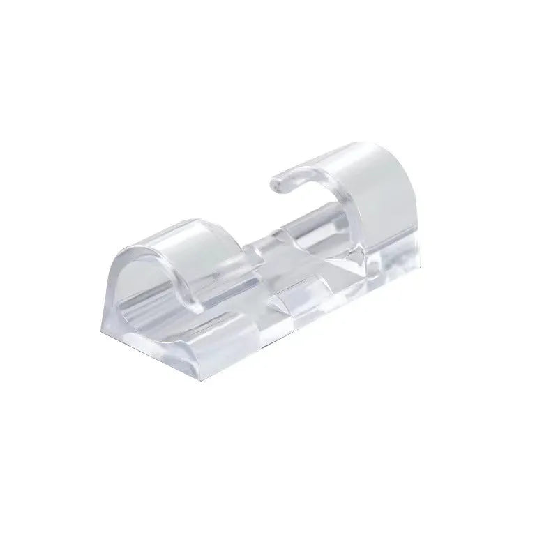 Transparent plastic self-adhesive cable clips for wire management on a desk.