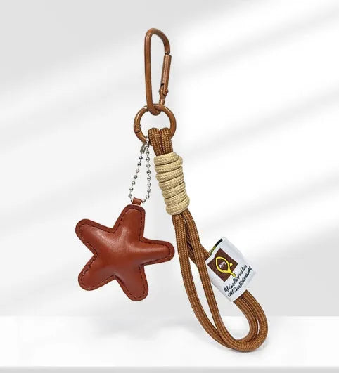 Handmade soda bread style handbag pendant with cartoon croissant design and brown star on brown strap