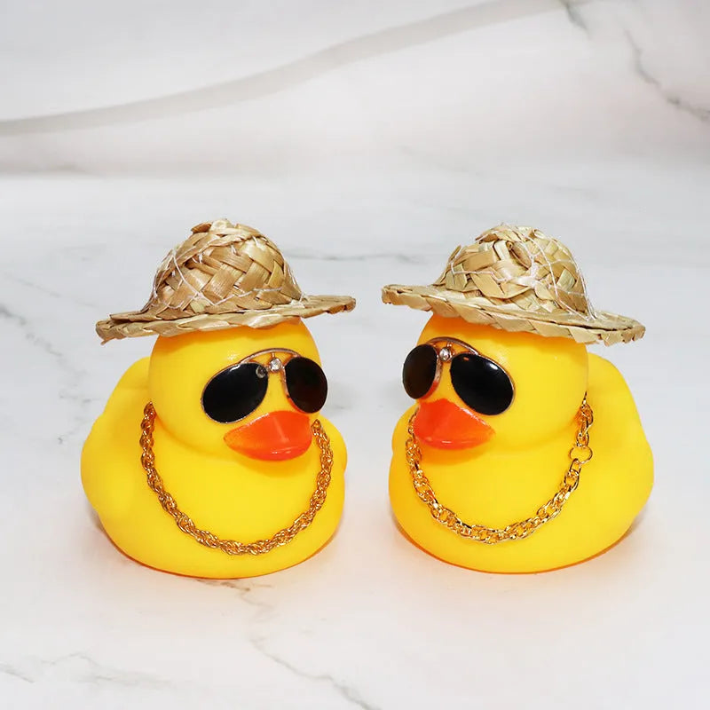 Matte yellow cartoon duck wearing a straw hat car ornament on a dashboard.