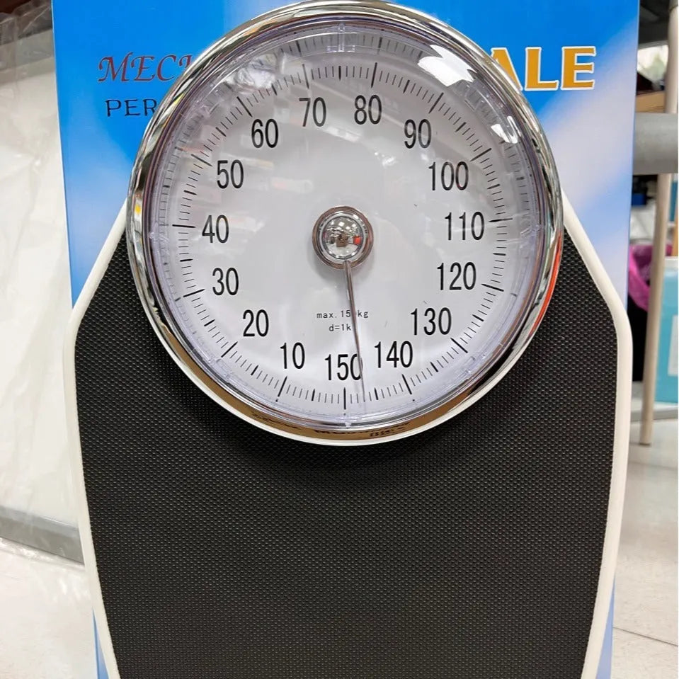 Black mechanical bathroom scale with large analogue dial showing weight measurement