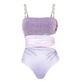 Purple women's one-piece swimsuit with matching wrap skirt on beach