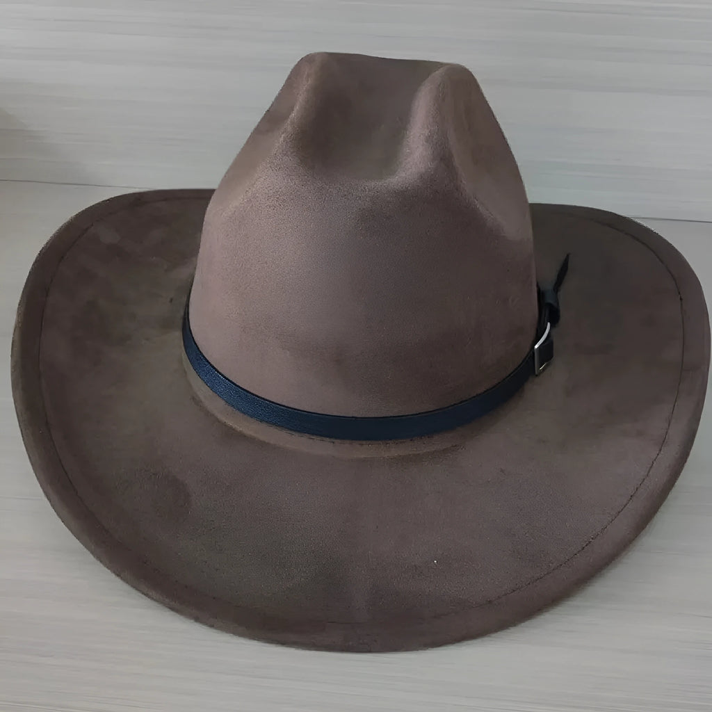 Brown leather cowboy hat with curved brim and conical crown on wooden surface