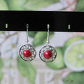 Handmade geometric flower disk earrings in Tibetan silver and turquoise, showing totem patterns.