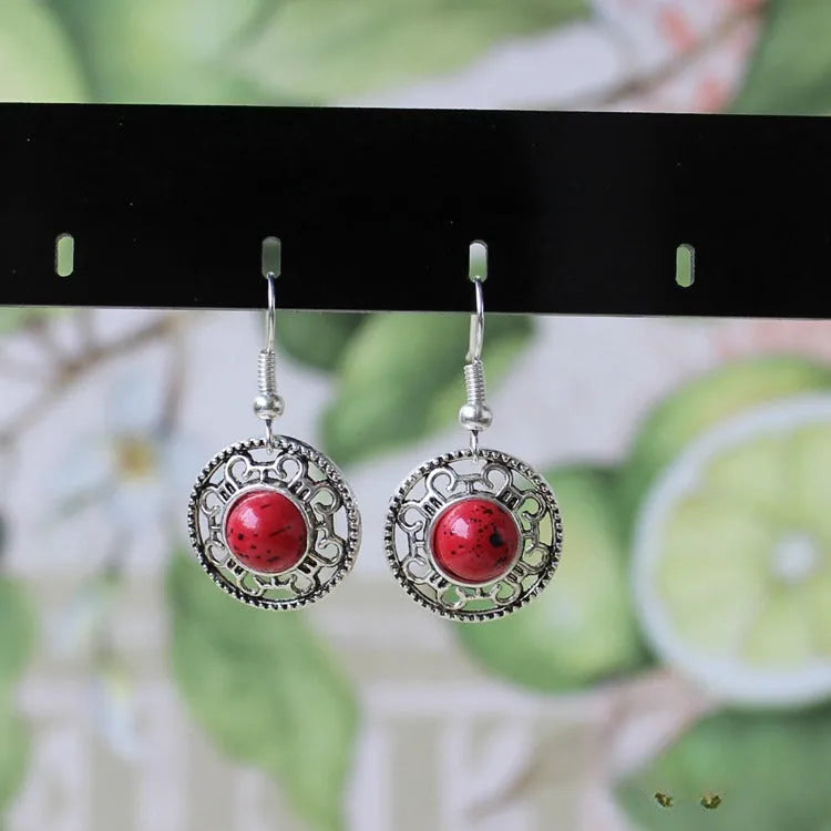 Handmade geometric flower disk earrings in Tibetan silver and turquoise, showing totem patterns.