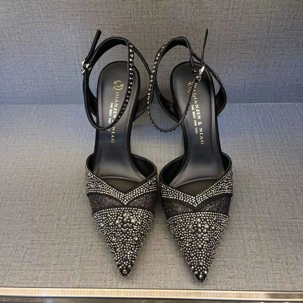 Women's black high heels with hollow stiletto heel, pointed toe, and a bright red sole.