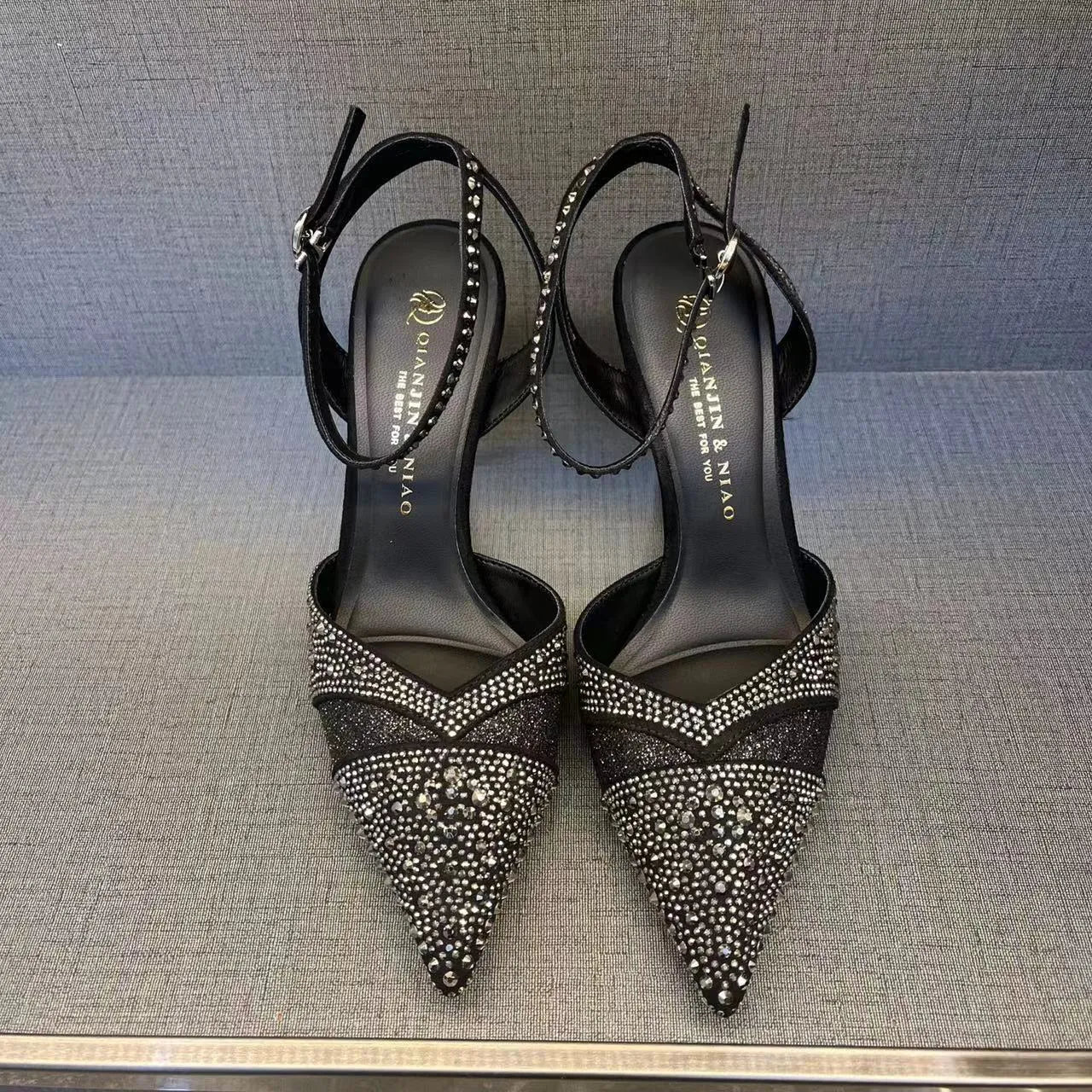 Women's black high heels with hollow stiletto heel, pointed toe, and a bright red sole.
