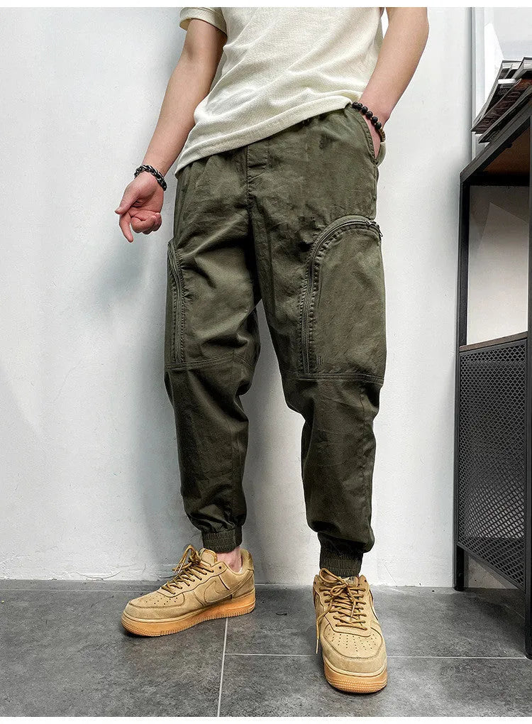 Men's elastic waist cotton cargo trousers with zippered pockets, loose fit, in khaki colour on plain background