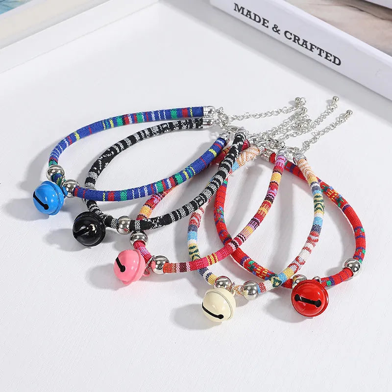 Coloured ethnic style adjustable pet collar with a bell for cats and dogs in black, blue, pink, red, and white.