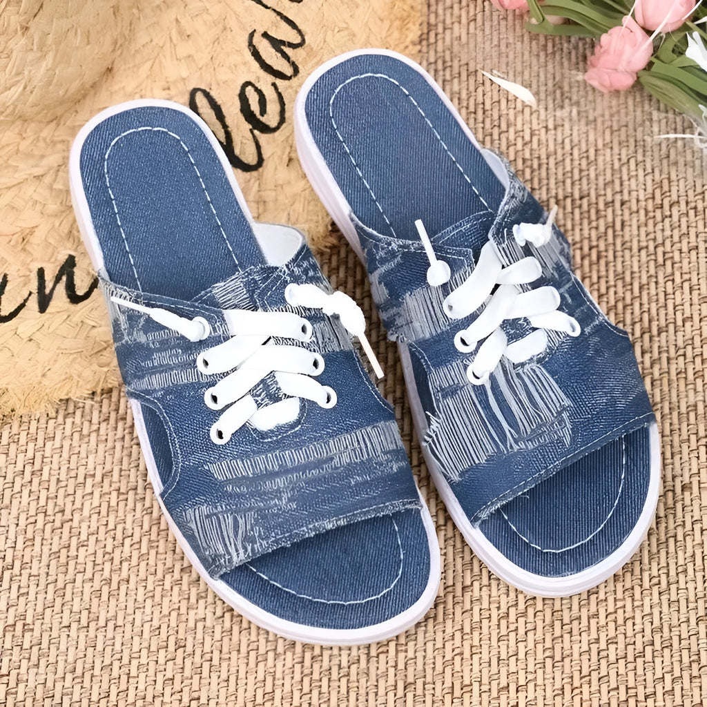 Blue Roman style women's flat canvas slippers with cloth lining, shown from the side.