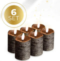 Four black LED pillar candles with flickering flame effect on a table.