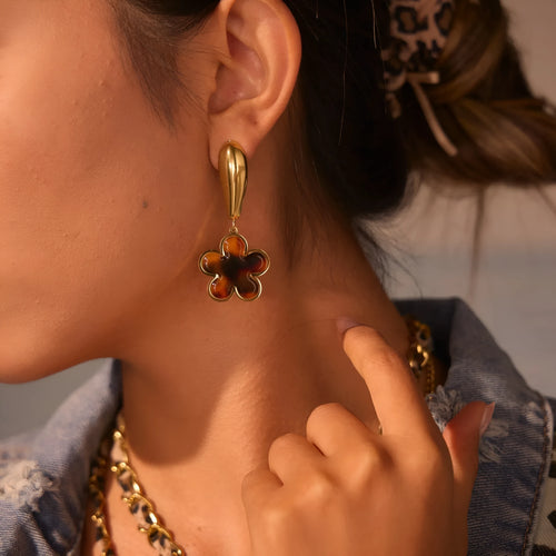Close up of 18K gold plated stainless steel earrings featuring tortoiseshell resin in heart and flower geometric shapes for women.