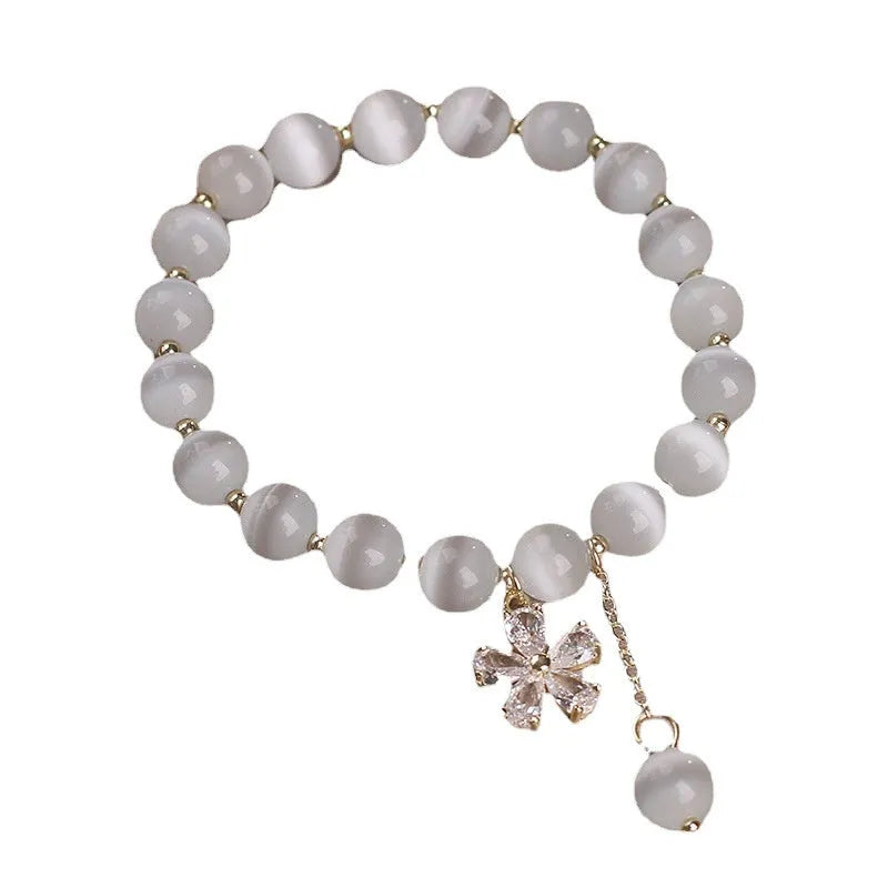 Single loop white cat's eye crystal bracelet with flower tassel and morganite safety buckle for women.