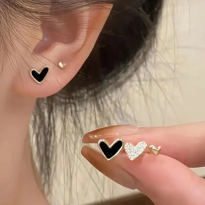 Three pairs of women's heart-shaped alloy earrings in electroplated gold, black, black-white, or pink colours