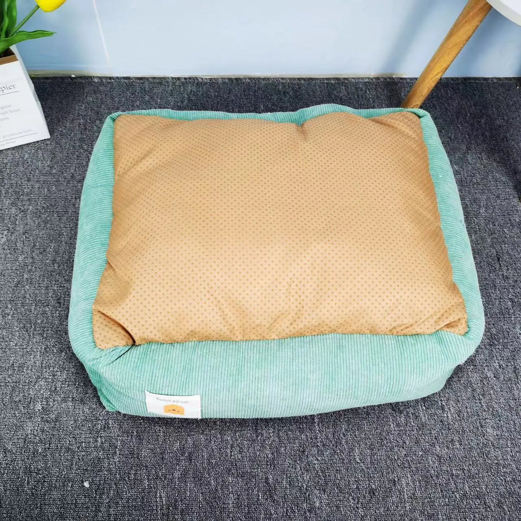 Light blue cotton winter dog nest bed with soft padded interior, shown empty on a wooden floor.