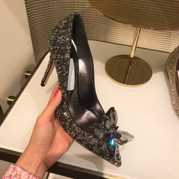 Gold women's pointed toe high heels with rhinestones and a stiletto heel on a white background.
