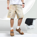 Light blue ripped denim shorts for men on a mid-thigh model, showing straight-leg cut and distressed details.
