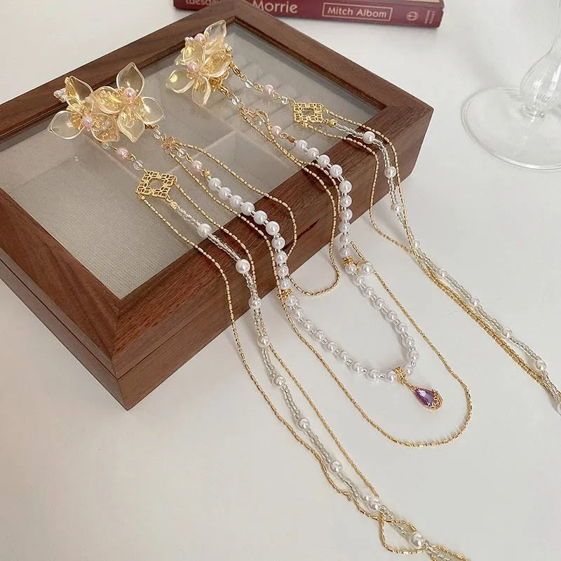 Gold acrylic hairpin with pearl, diamond, and long tassel decorative elements for women's hairstyling.