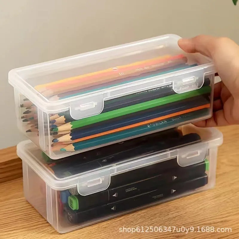 Clear plastic pencil storage box showing coloured pencils and drawing tools inside.